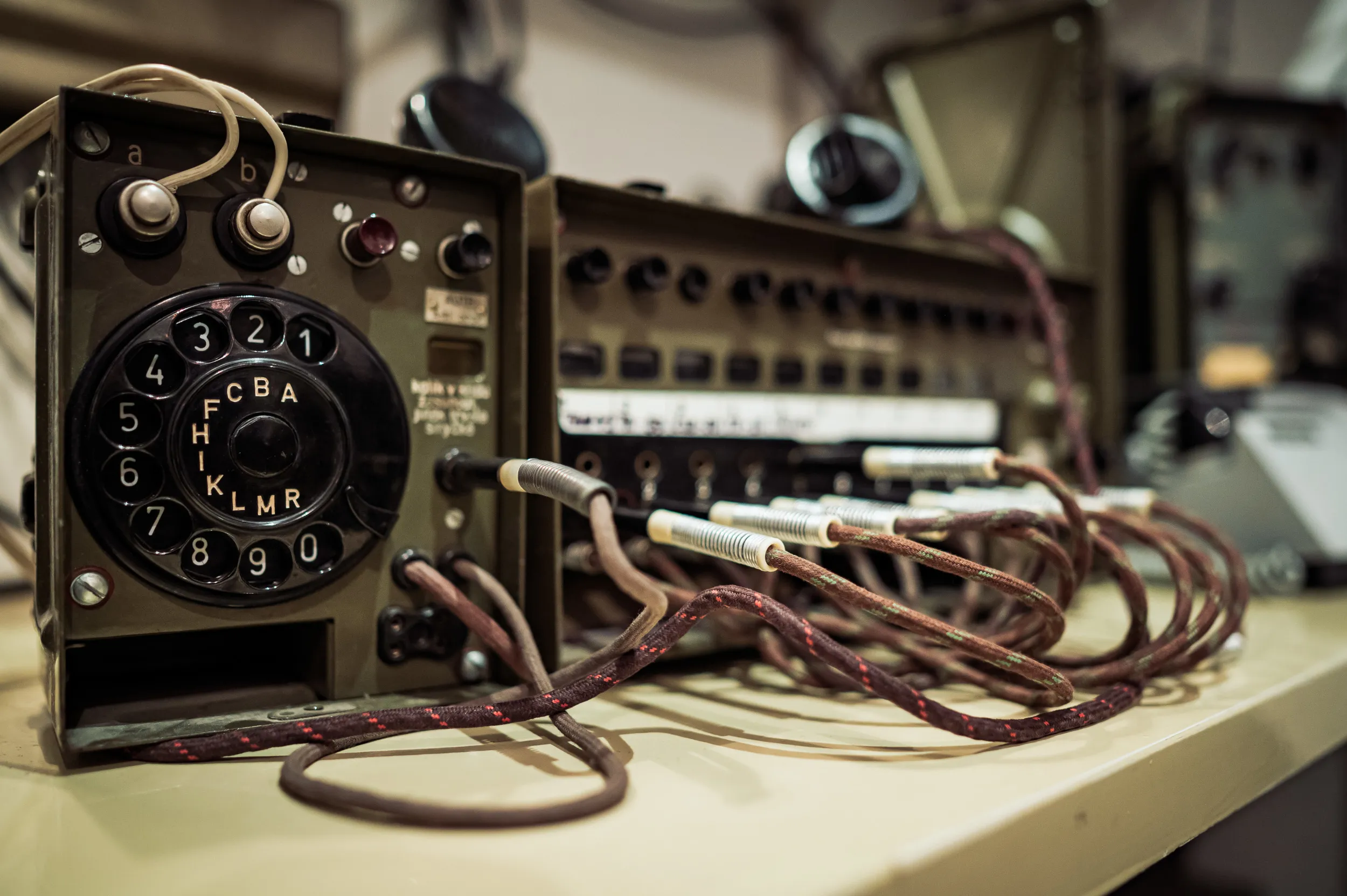 vintage rotary telephone and communication equipment with coiled wires on a table