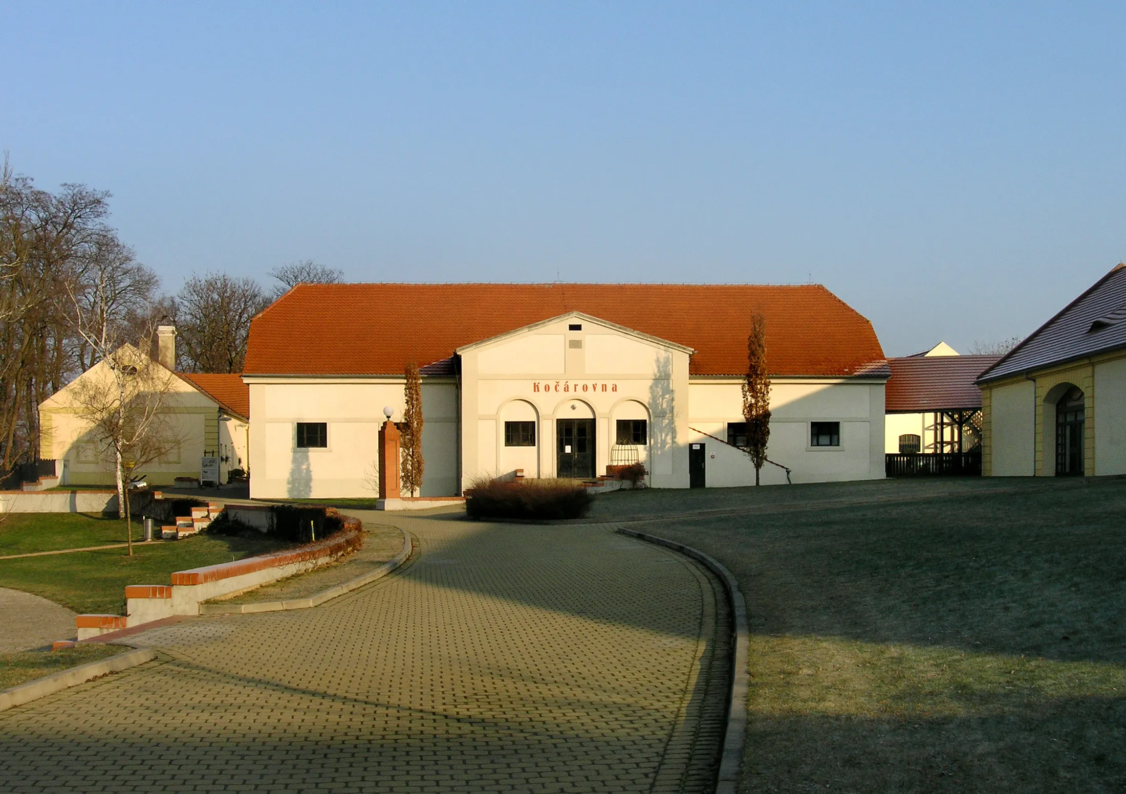 wit gebouw met rood pannendak en 'KULTURNÍ CENTRUM'-bord bij Kasteel Ctěnice