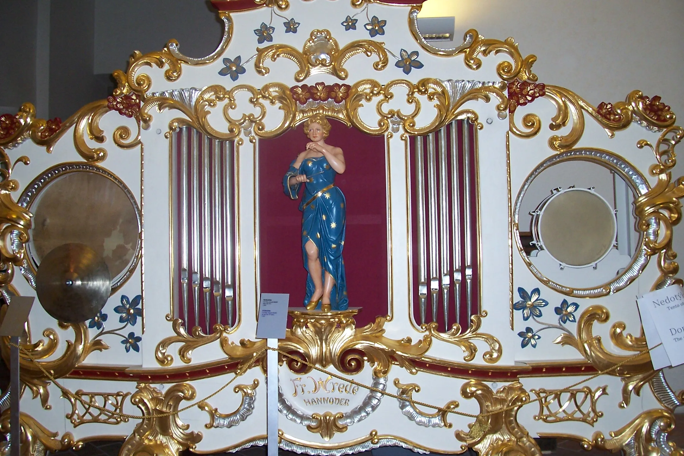 Ornate baroque organ with gold and white detailing and a central statue of a figure in blue