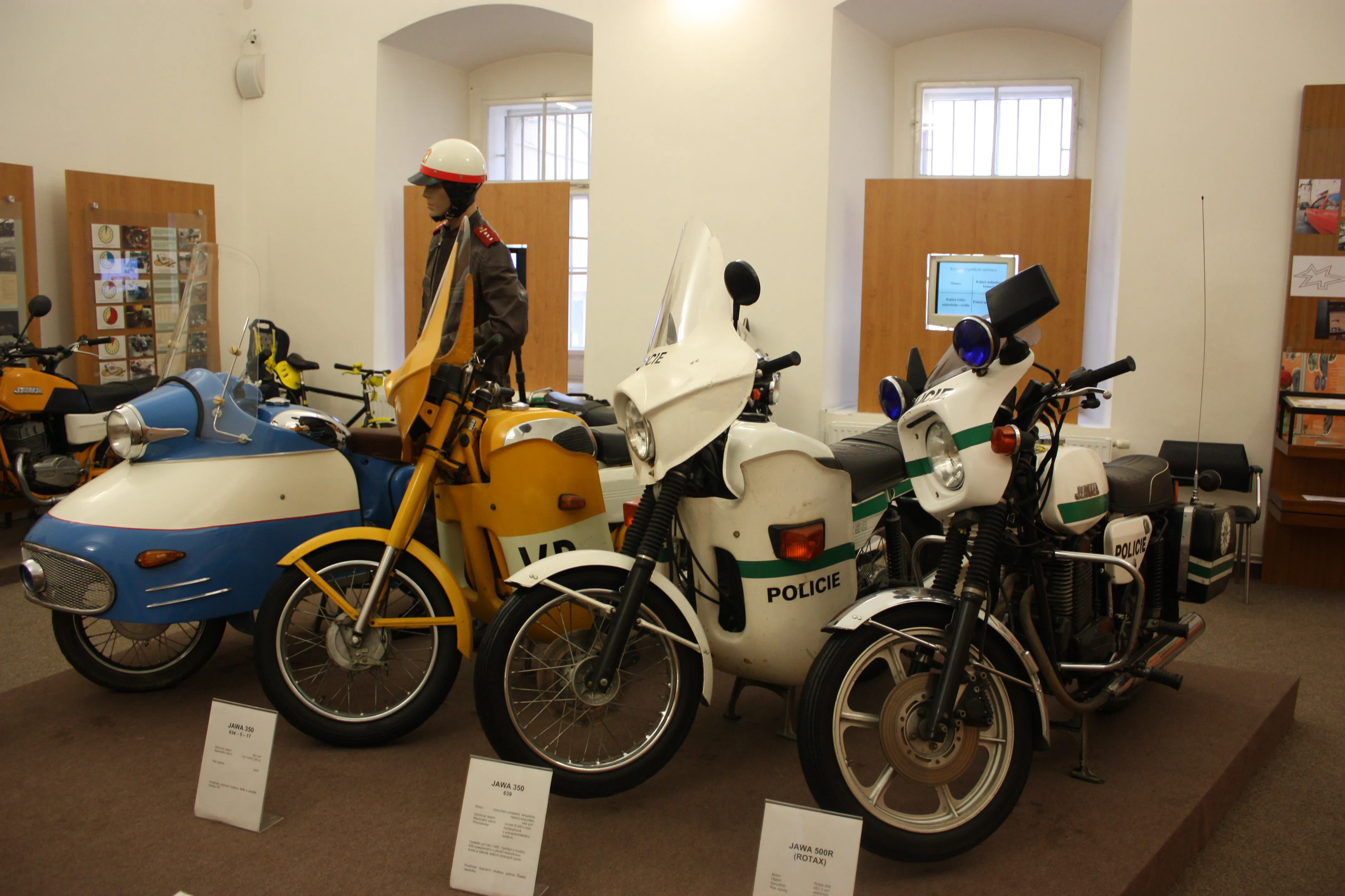 vintage police motorcycles and scooters on display in a museum