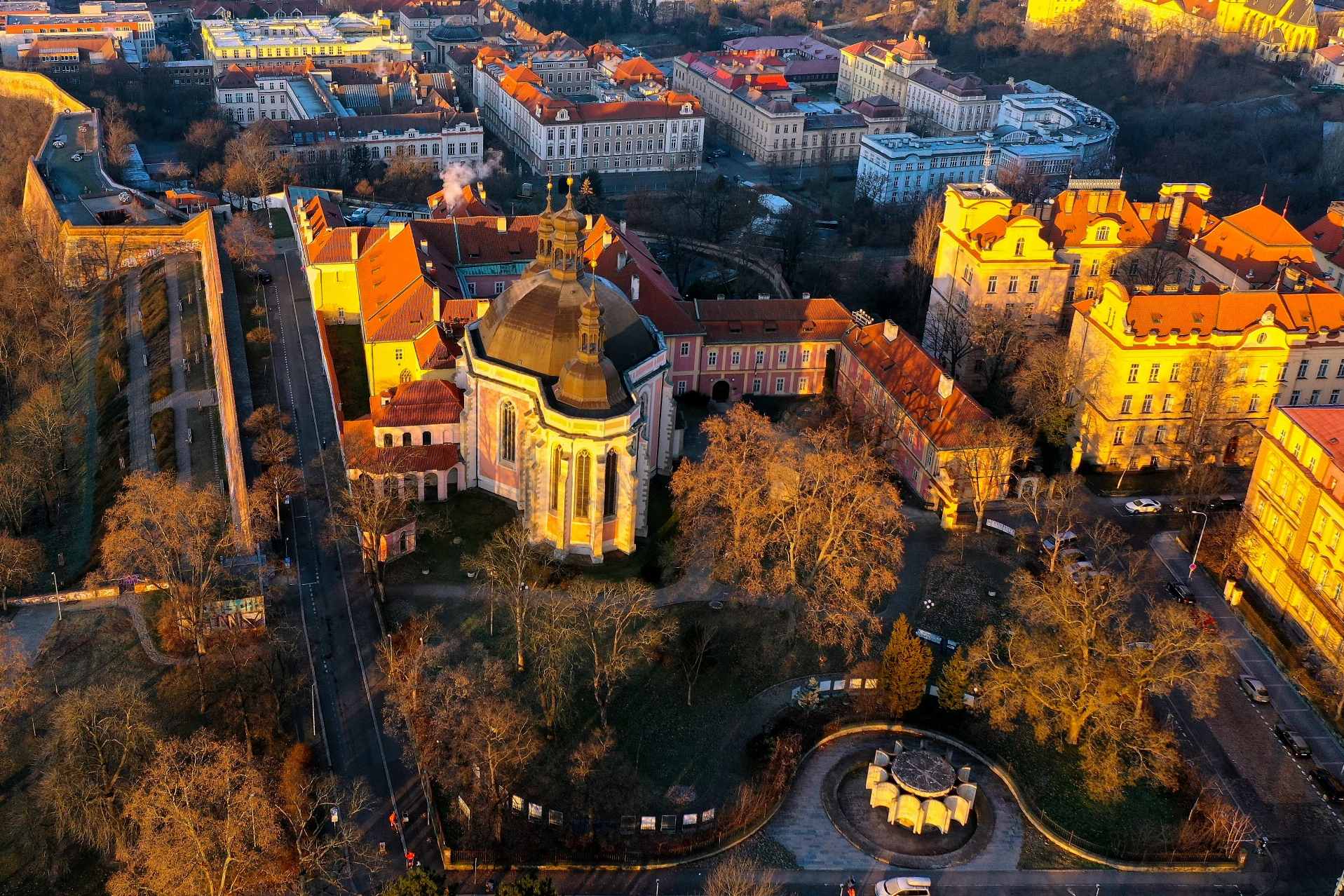 Aerial view of a historic building with a dome surrounded by trees and urban structures