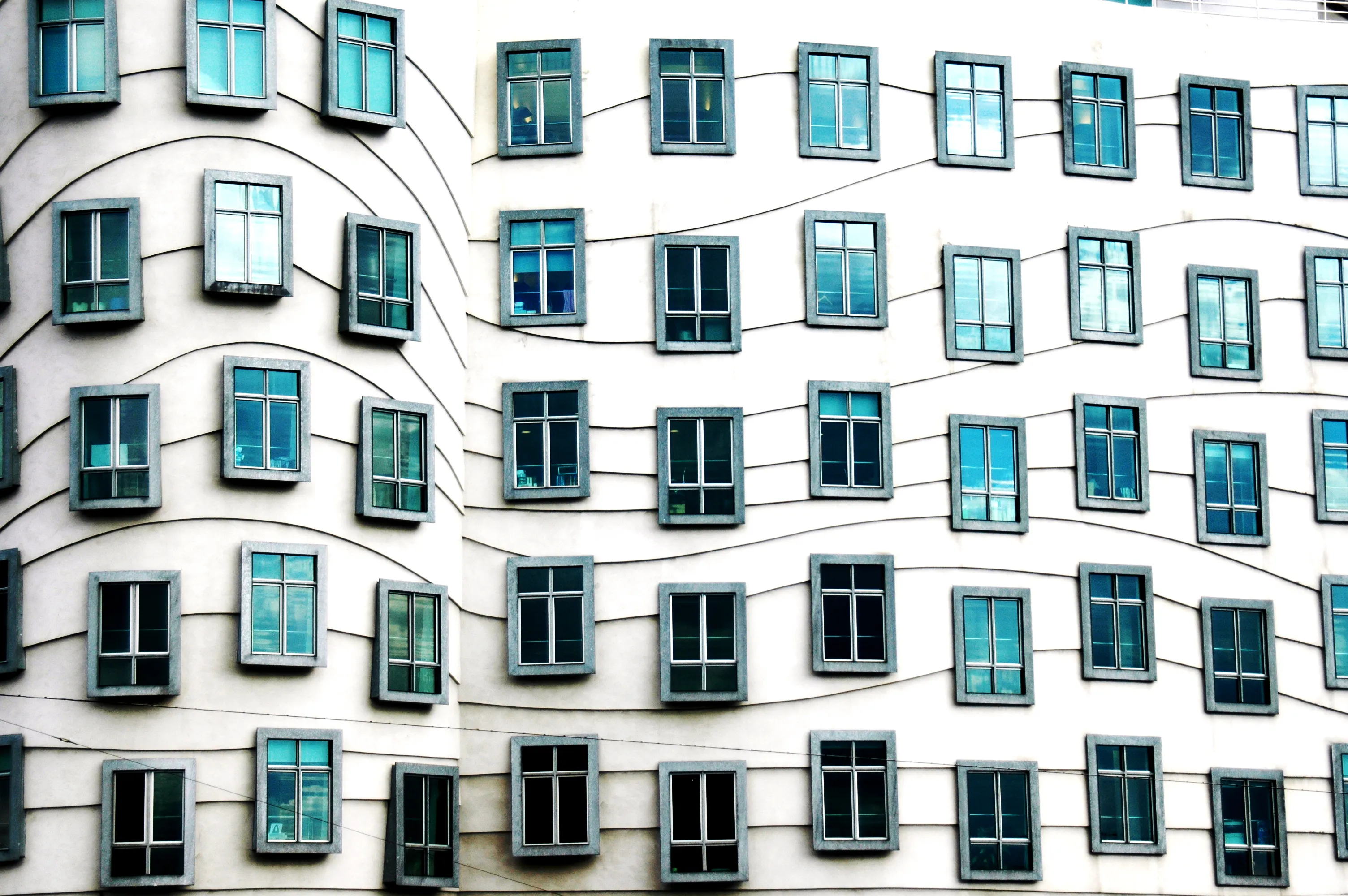 Primer plano de la fachada ondulada de la Casa Danzante con ventanas de colocación irregular