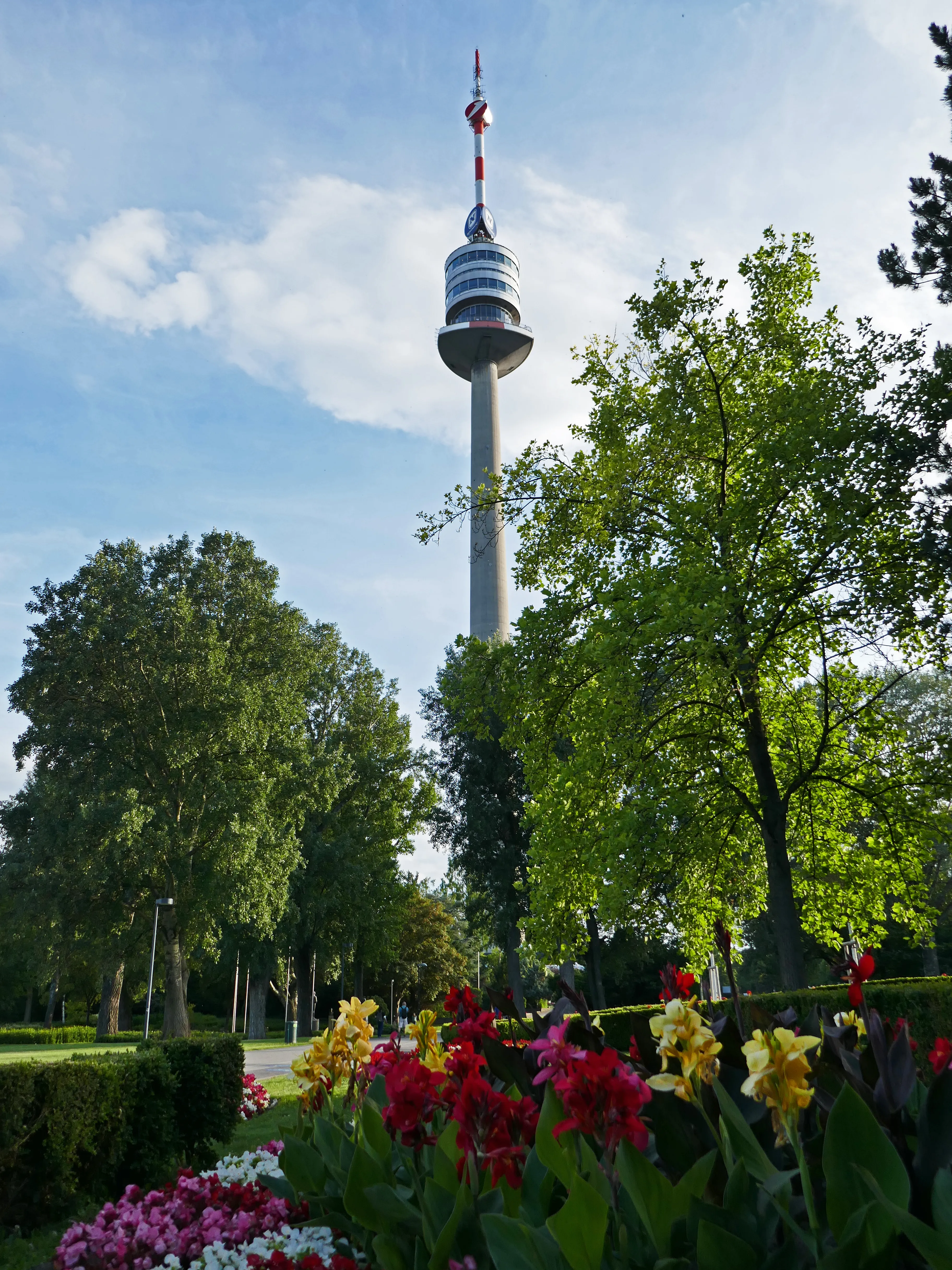 Danube Tower visible behind trees and flowers in a park