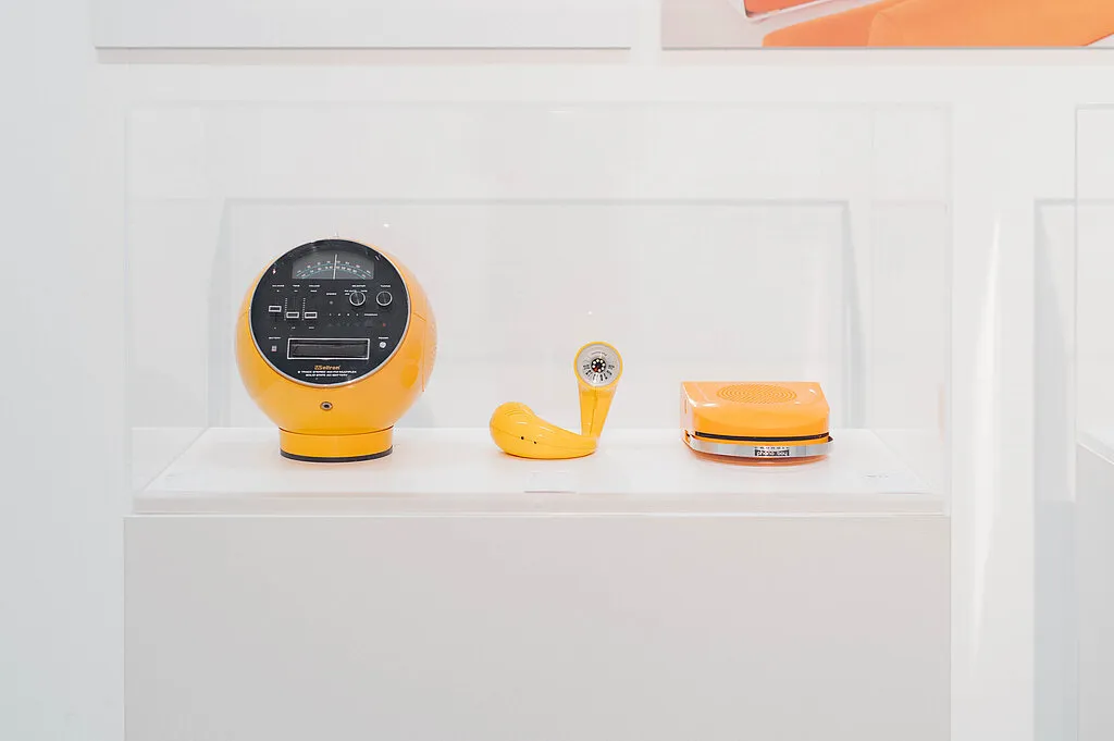 tres objetos de diseño amarillos en un estante de exhibición blanco