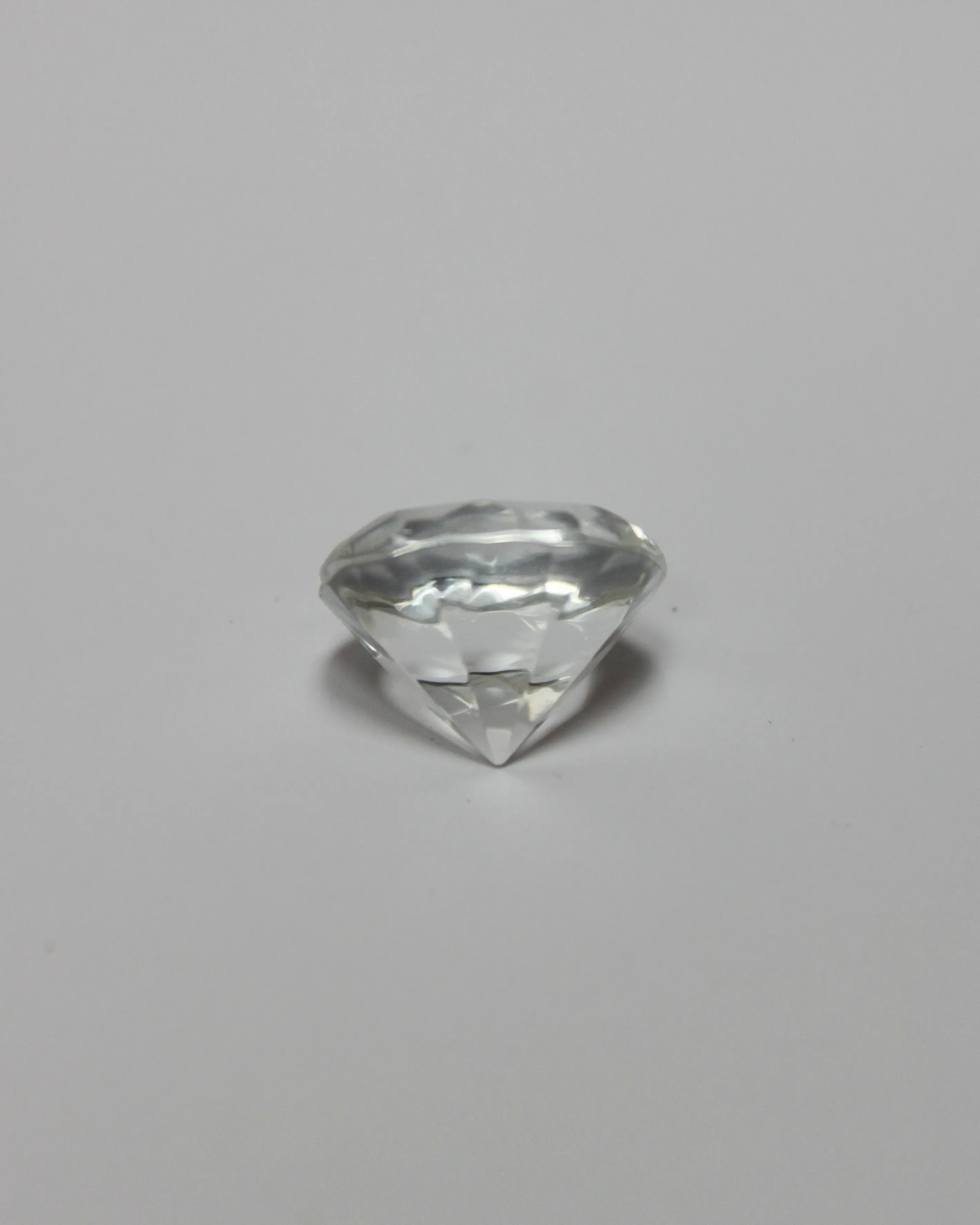 Un diamante de corte limpio sobre un fondo gris claro liso.