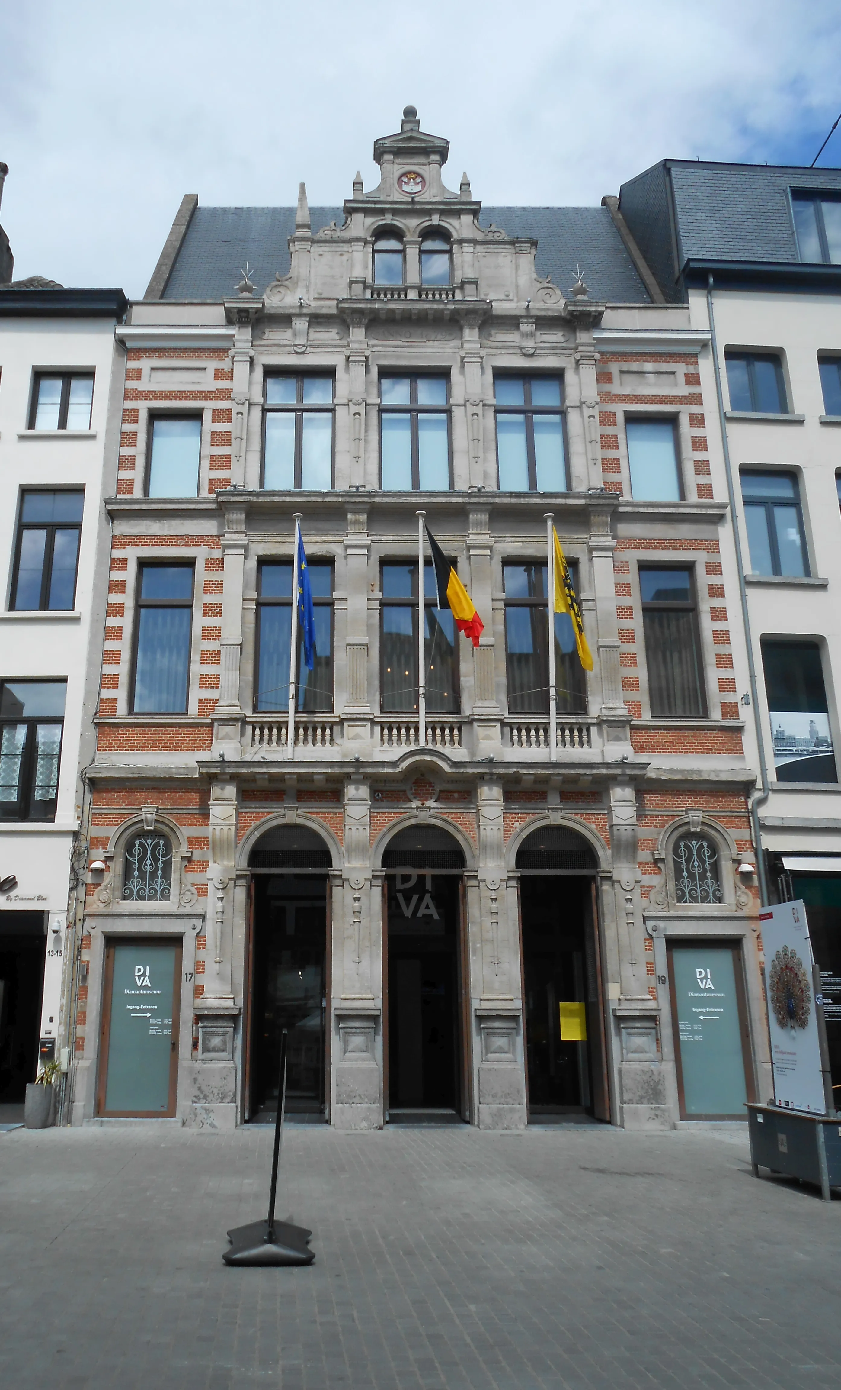 Fachada principal del edificio del museo DIVA con arquitectura neorrenacentista de ladrillo y piedra, entradas arqueadas con señalización DIVA y banderas ondeando en la parte superior.