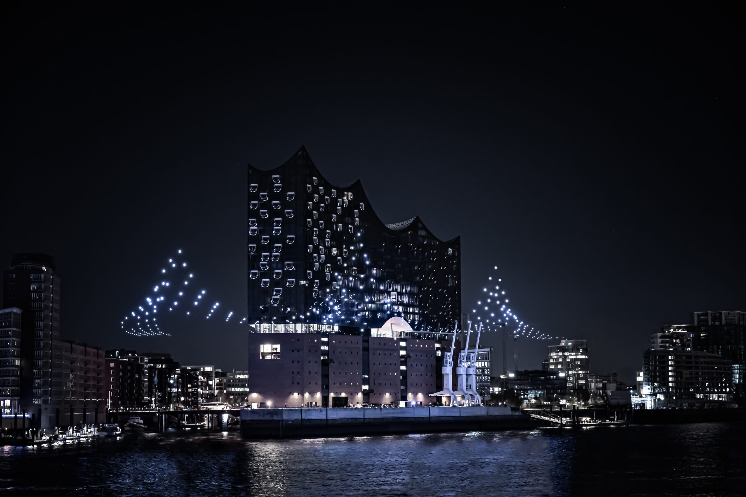 illuminated building with blue lights at night near water