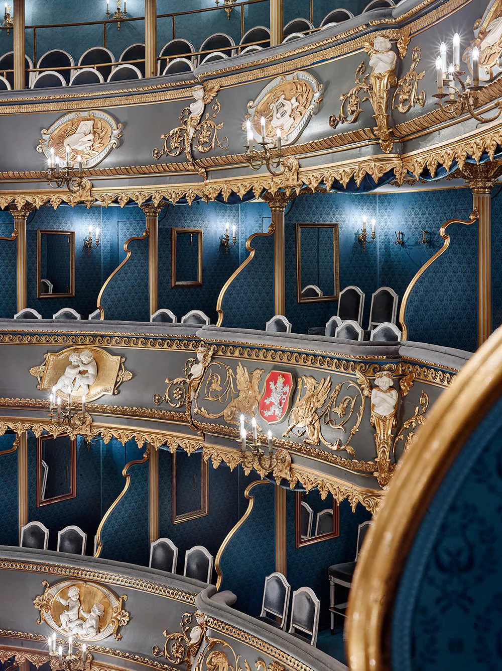 Ornate interior of the Estates Theatre with blue walls, gold trim, and multiple levels of balconies