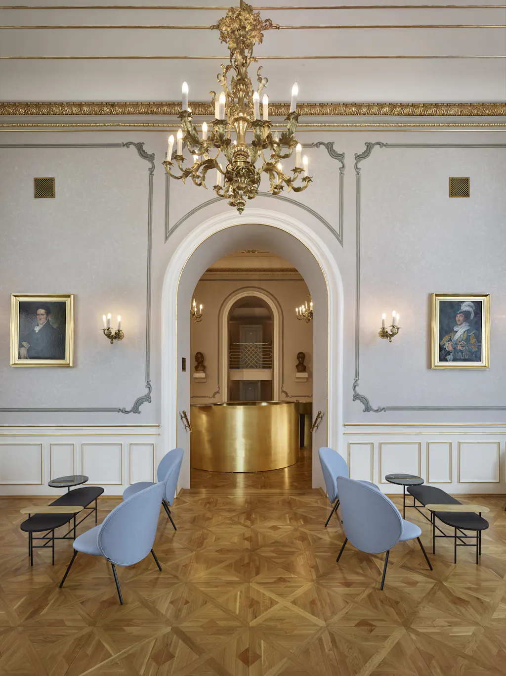 Sierlijk interieur van het Estates Theatre met een grote kroonluchter, gouden accenten en moderne stoelen op een parketvloer