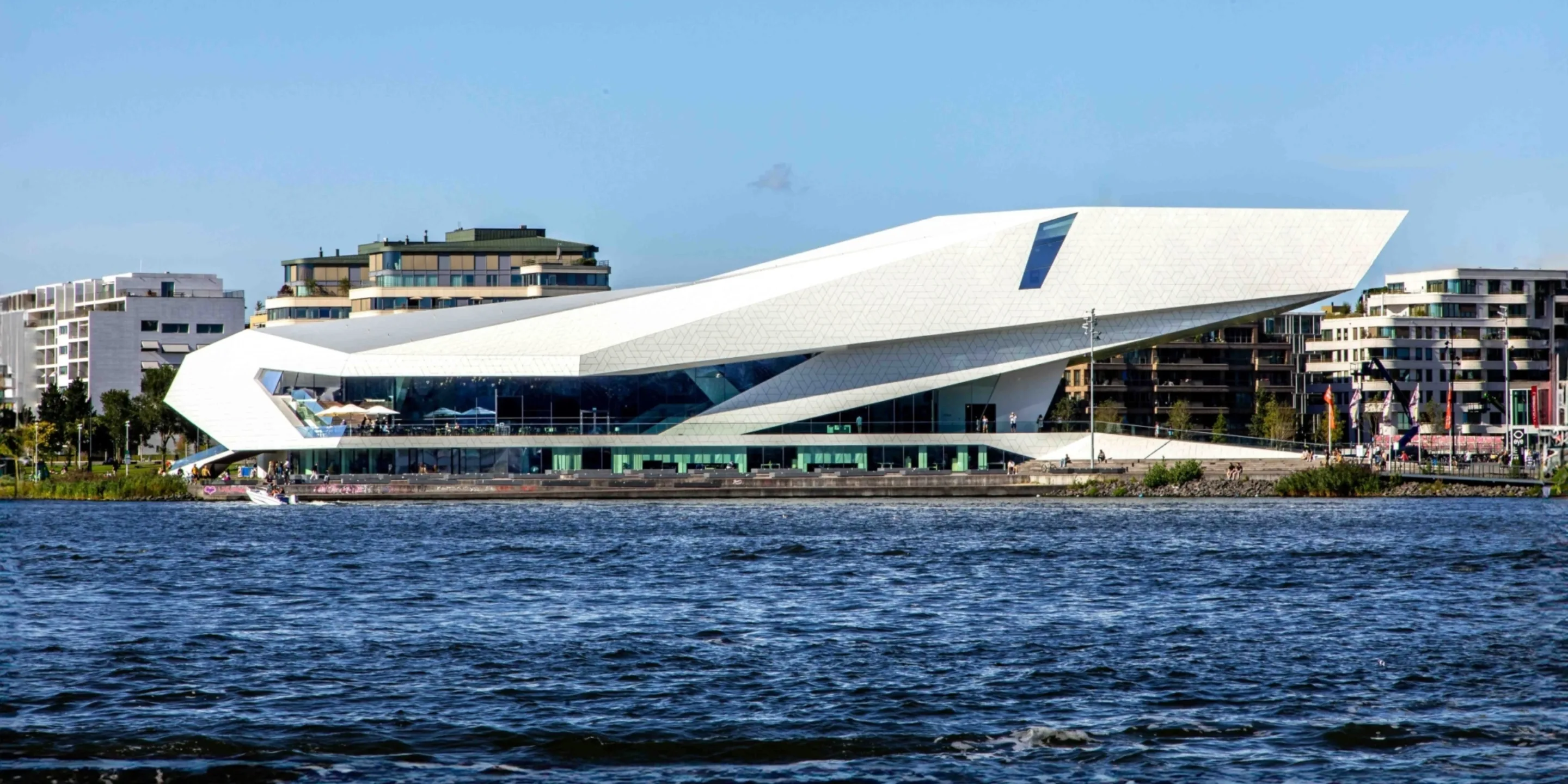 Modern white angular building with unique architecture situated along a body of water, identified as Eye Filmmuseum