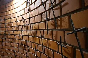 pared de ladrillos con cruces de metal montadas en ella