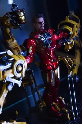 Un traje de Iron Man rojo y dorado expuesto con brazos robóticos y componentes mecánicos