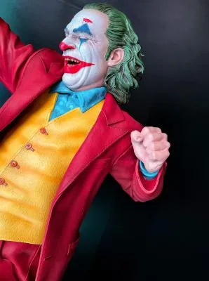 Figura del Joker con abrigo rojo y chaleco amarillo, pelo verde y maquillaje de payaso