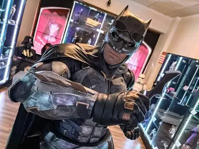 Disfraz de Batman en exhibición en un museo con vitrinas e iluminación