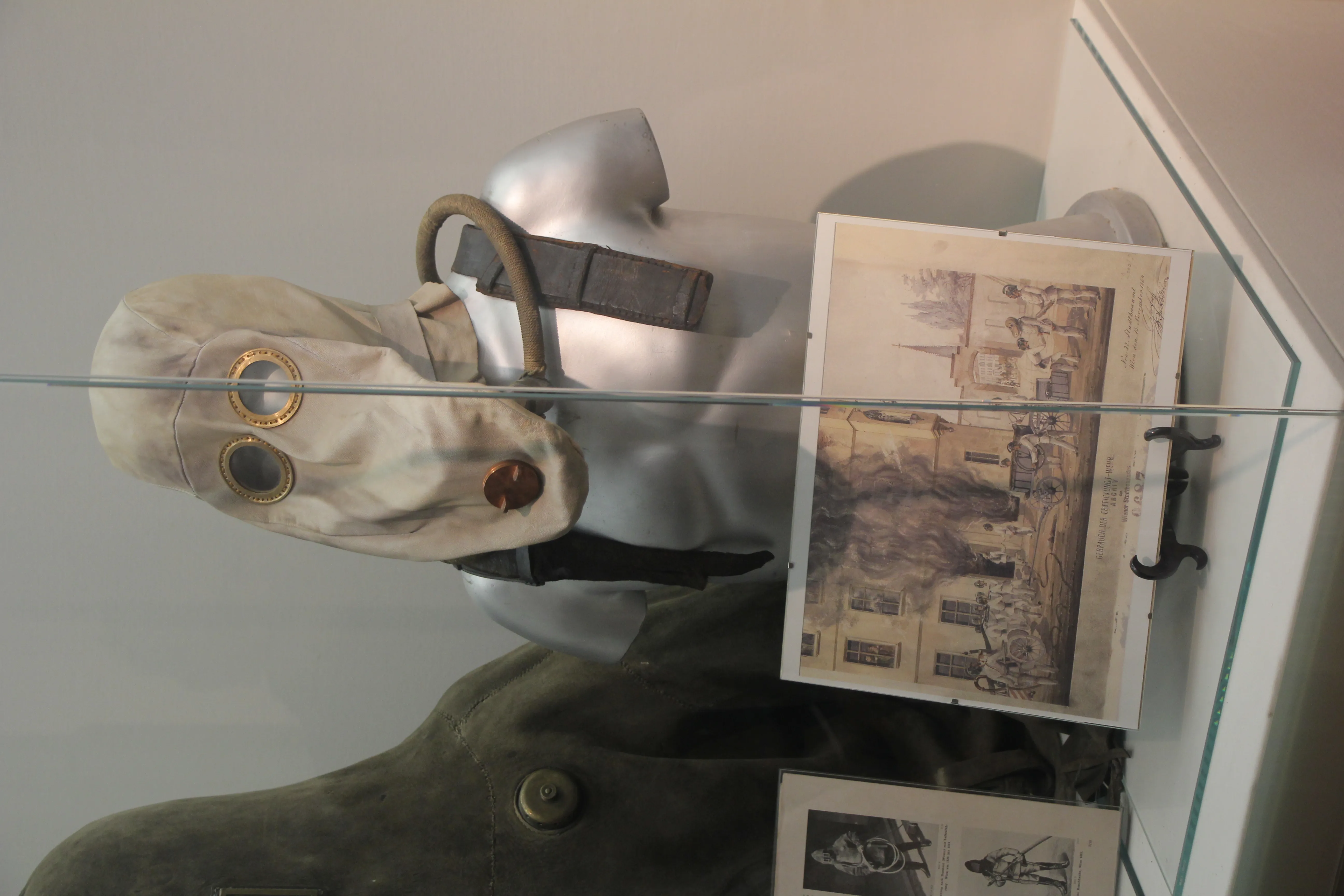 historyczna maska gazowa i fotografia w szklanej gablocie