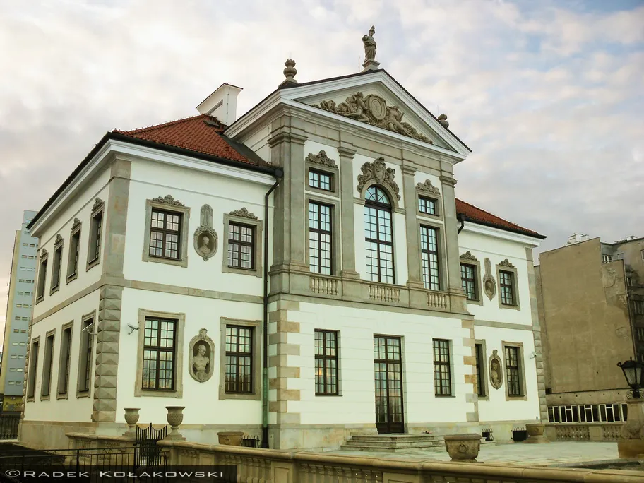 Neoclassical building with white facade, red roof, and decorative elements