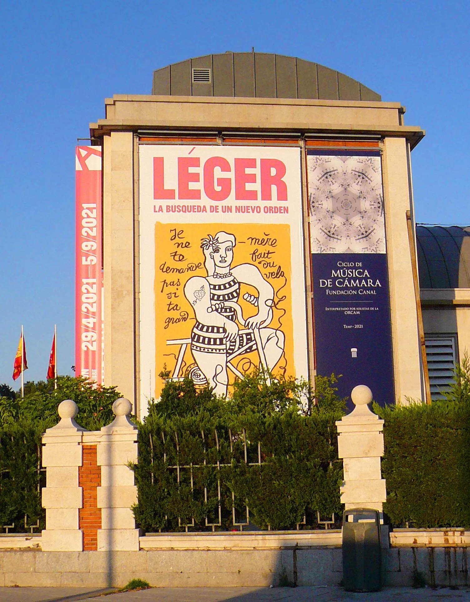 Exterior de Fundación Canal con grandes carteles de exposiciones en la fachada, incluyendo uno de Léger y otro de un ciclo de música, contra un cielo azul claro.