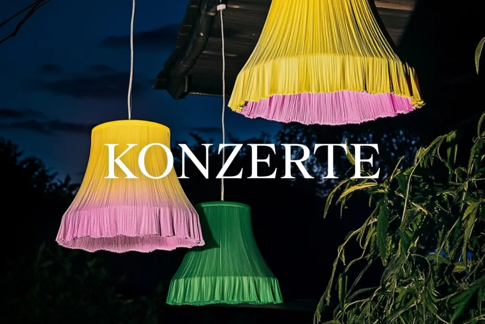 Trzy kolorowe, plisowane abażury wiszące na zewnątrz w nocy z napisem 'KONZERTE' nałożonym białym tekstem.