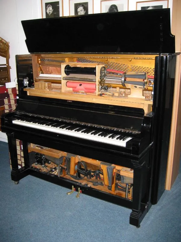 Black Steinway Welte pianola with its lid open, revealing the internal mechanical components and keyboard