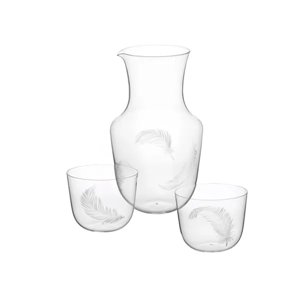 Jarra de vidrio y dos vasos con grabados de plumas