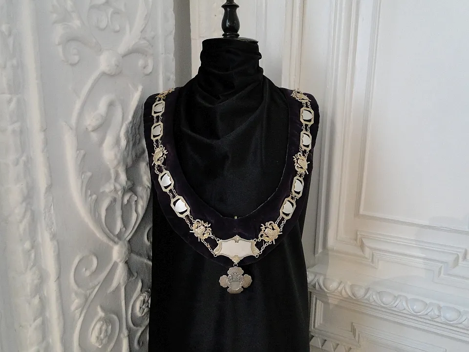 cadena de plata con eslabones ornamentados y medallón sobre maniquí negro