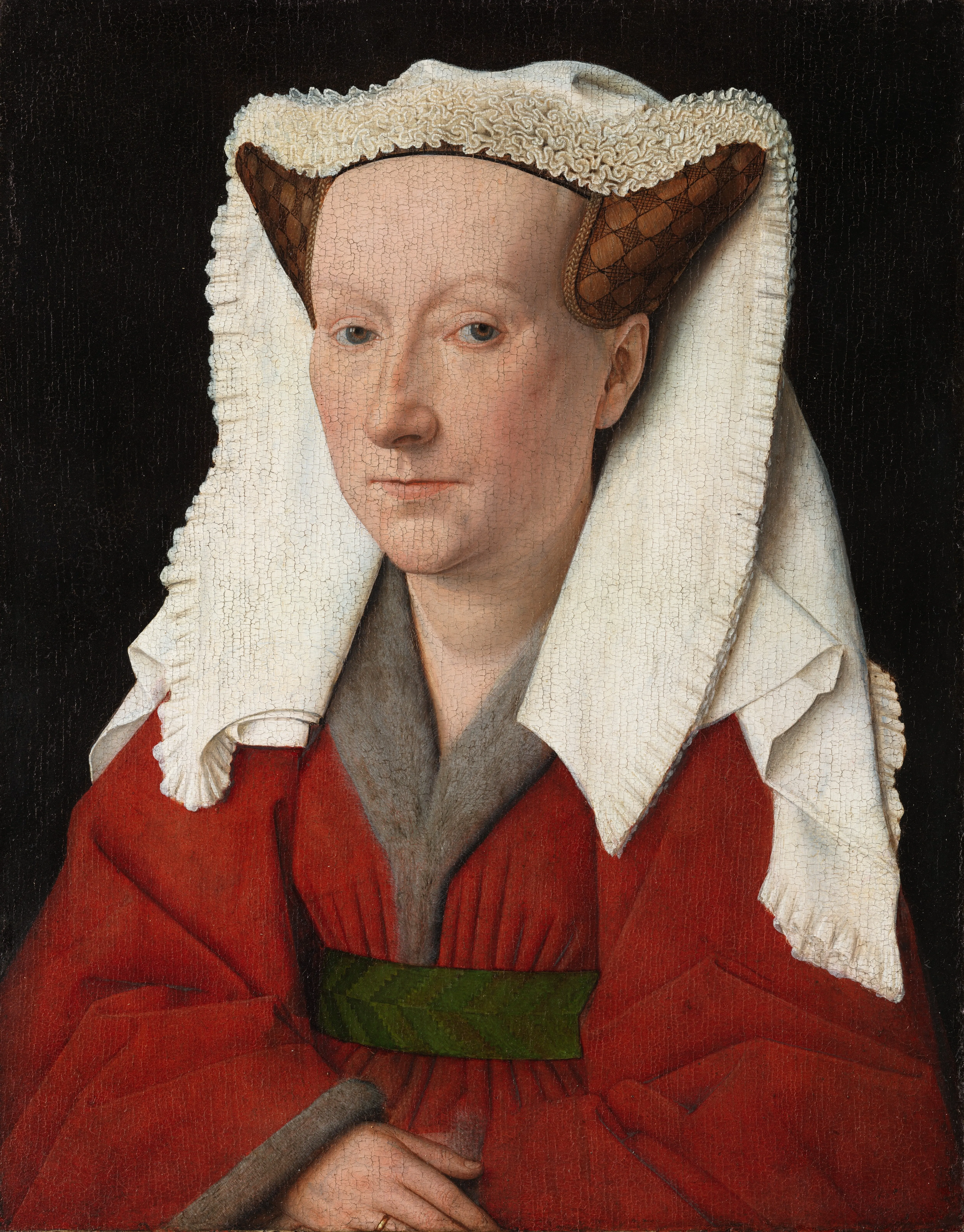 Retrato de una mujer con un tocado blanco y un vestido rojo con un cinturón verde sobre un fondo oscuro.