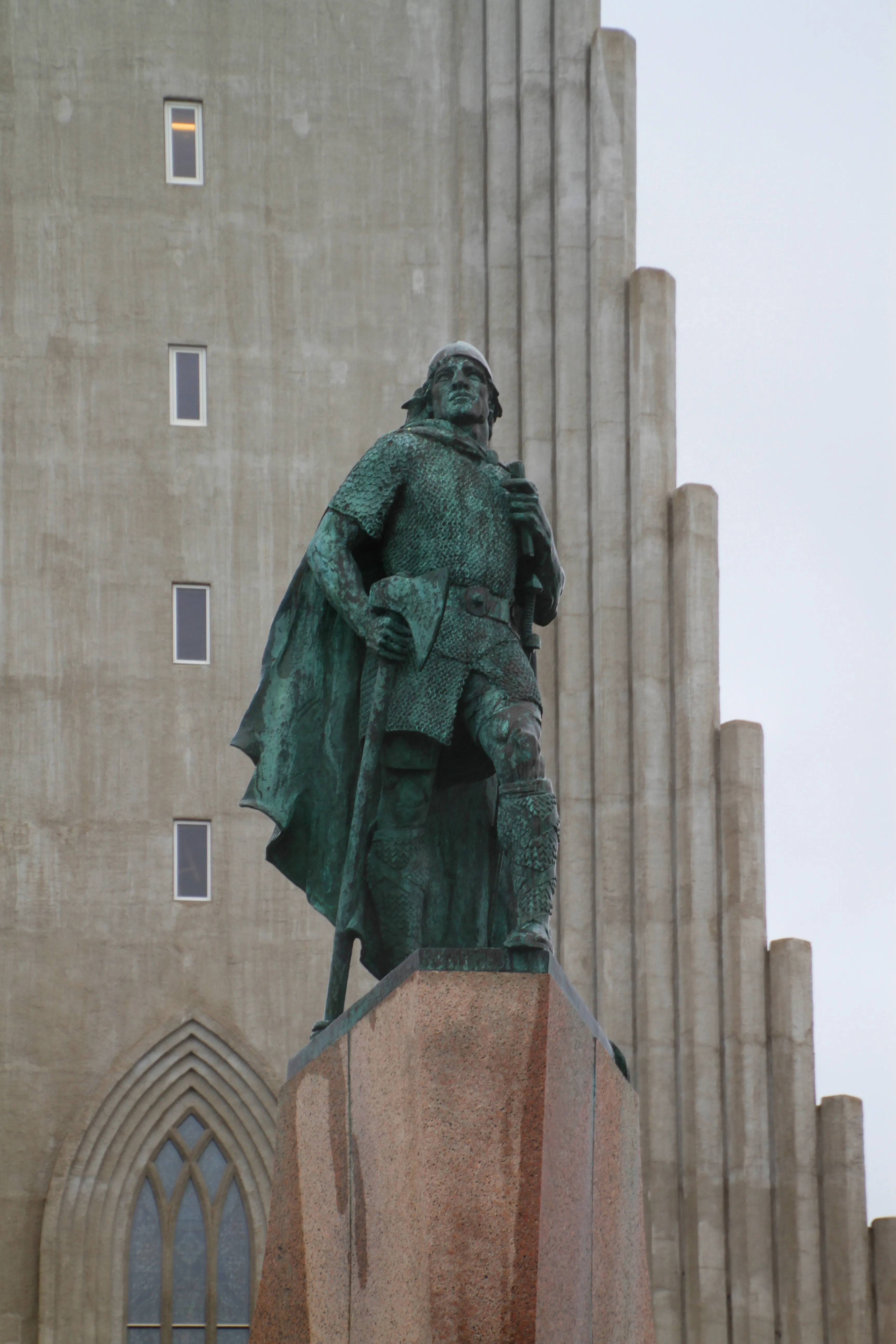 Bronzen standbeeld van Leifur Eiriksson op een stenen sokkel voor de basaltzuilen-gevel van de Hallgrímskirkja-kerk in Reykjavík