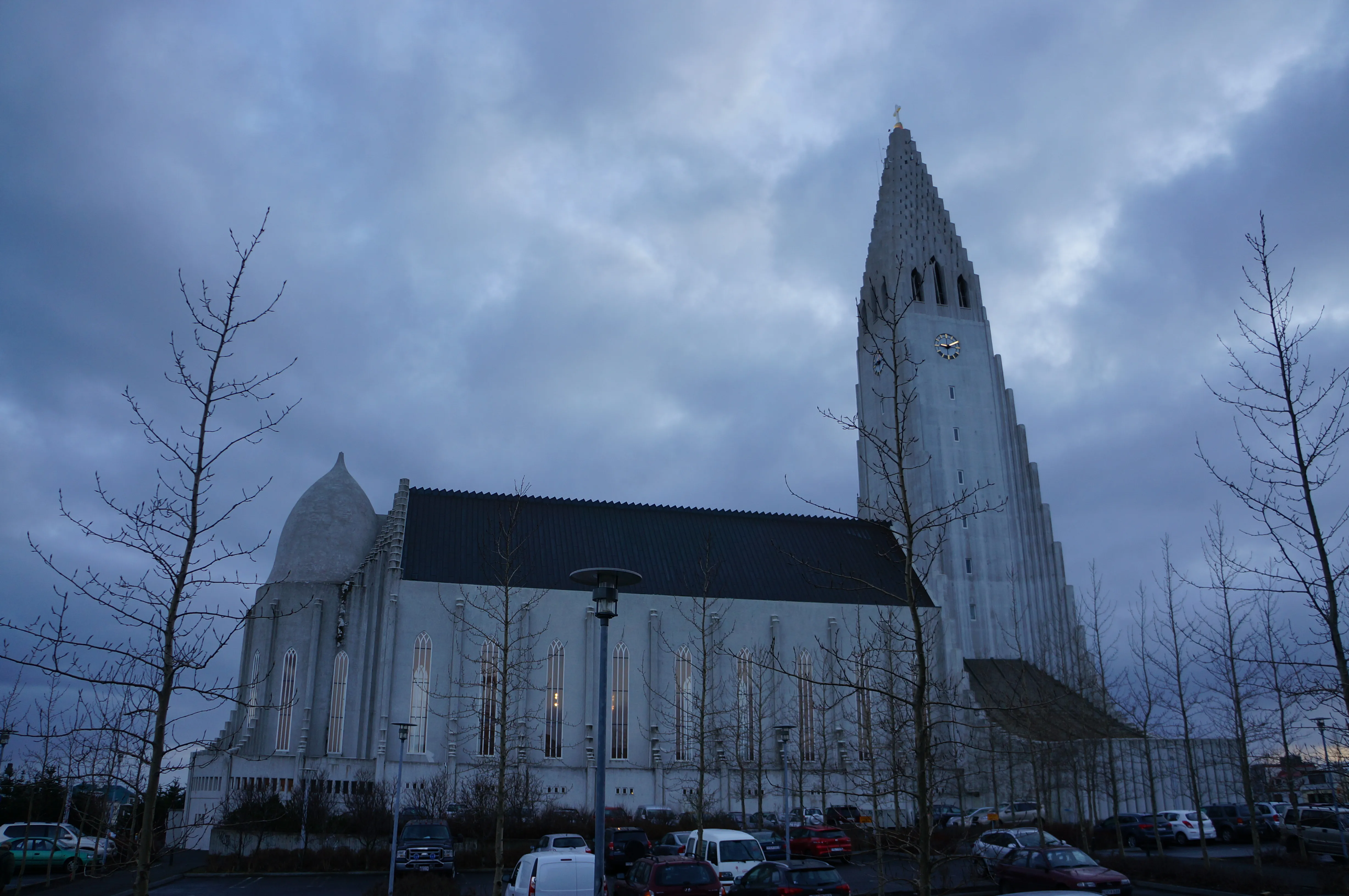 Buitenaanzicht van de Hallgrímskirkja-kerk in Reykjavík, met de hoge, opvallende toren en witte gevel onder een bewolkte hemel.