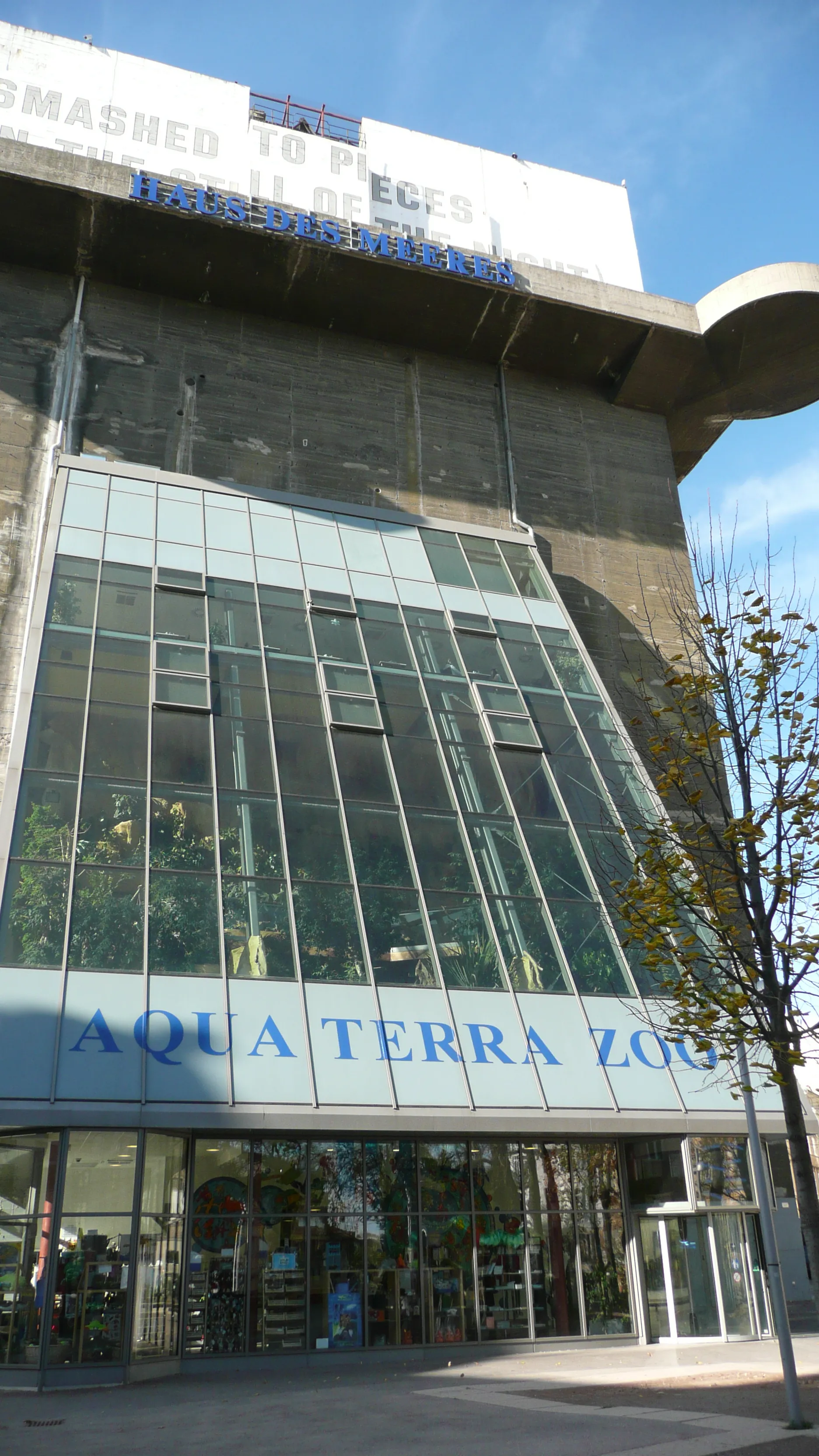 The exterior of Haus des Meeres, a large concrete building with a glass facade and blue signage reading 'Aqua Terra Zoo' and 'Haus des Meeres'.