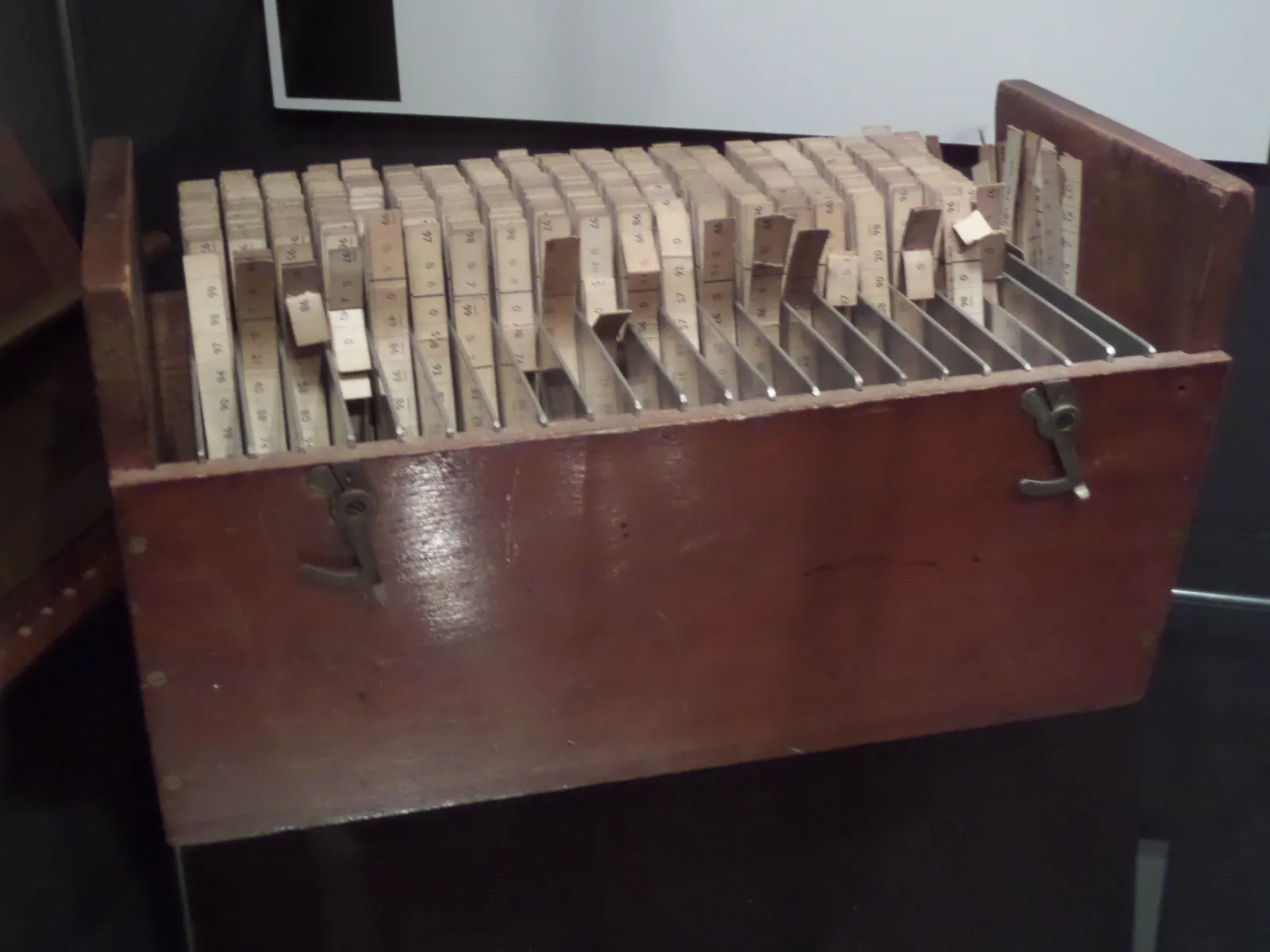 Caja de madera que contiene tiras de Beevers-Lipson, herramientas históricas de cálculo cristalográfico, expuesta en un museo