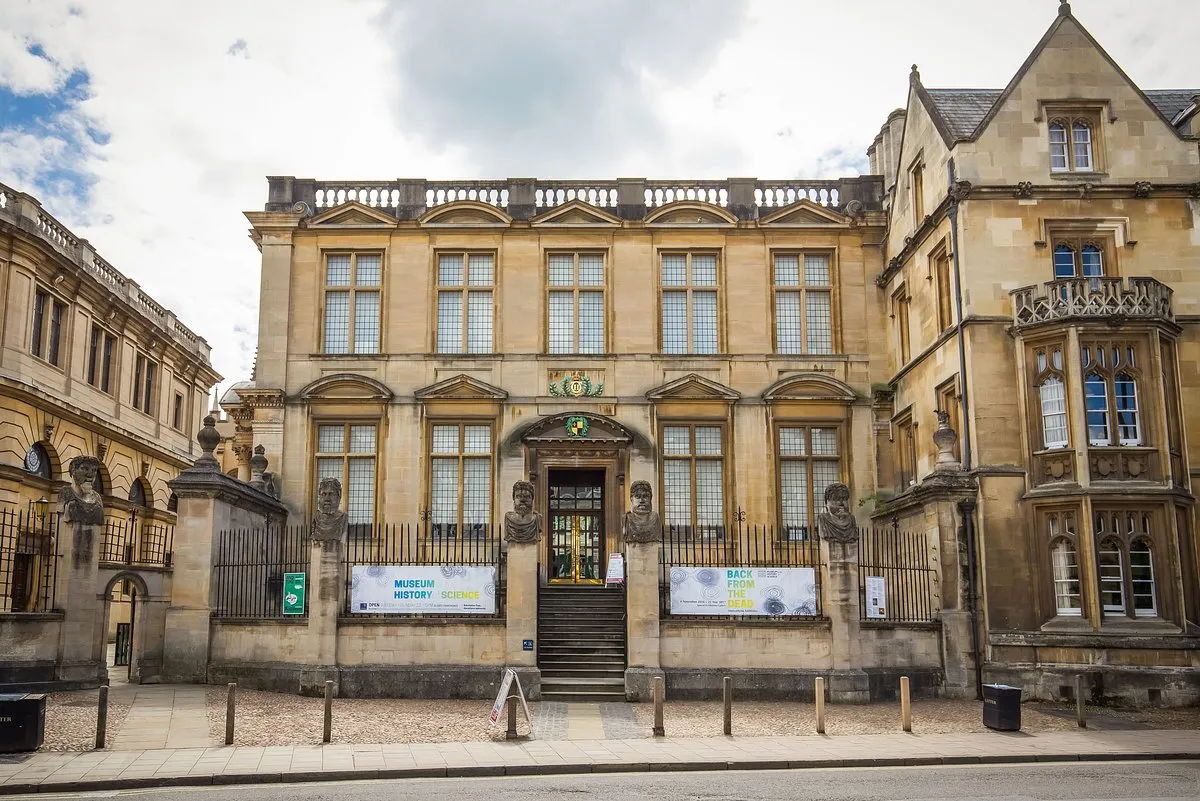 Fachada de piedra del History of Science Museum que muestra la histórica entrada del edificio Old Ashmolean con carteles en la verja de hierro