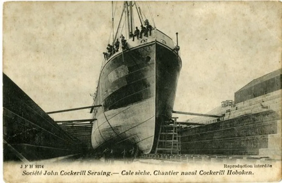 Postal vintage en blanco y negro que muestra un gran barco en un dique seco en el astillero naval Cockerill en Hoboken, con trabajadores visibles en la cubierta y texto a lo largo del borde inferior.