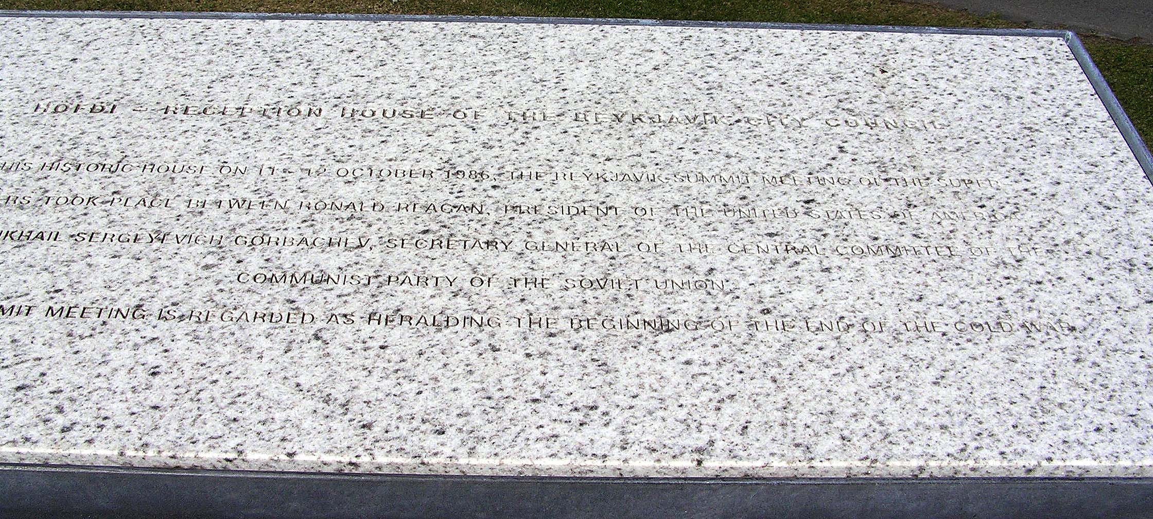 Close-up of a speckled granite plaque with engraved text commemorating the 1986 Reykjavík Summit between Ronald Reagan and Mikhail Gorbachev at Höfði House.