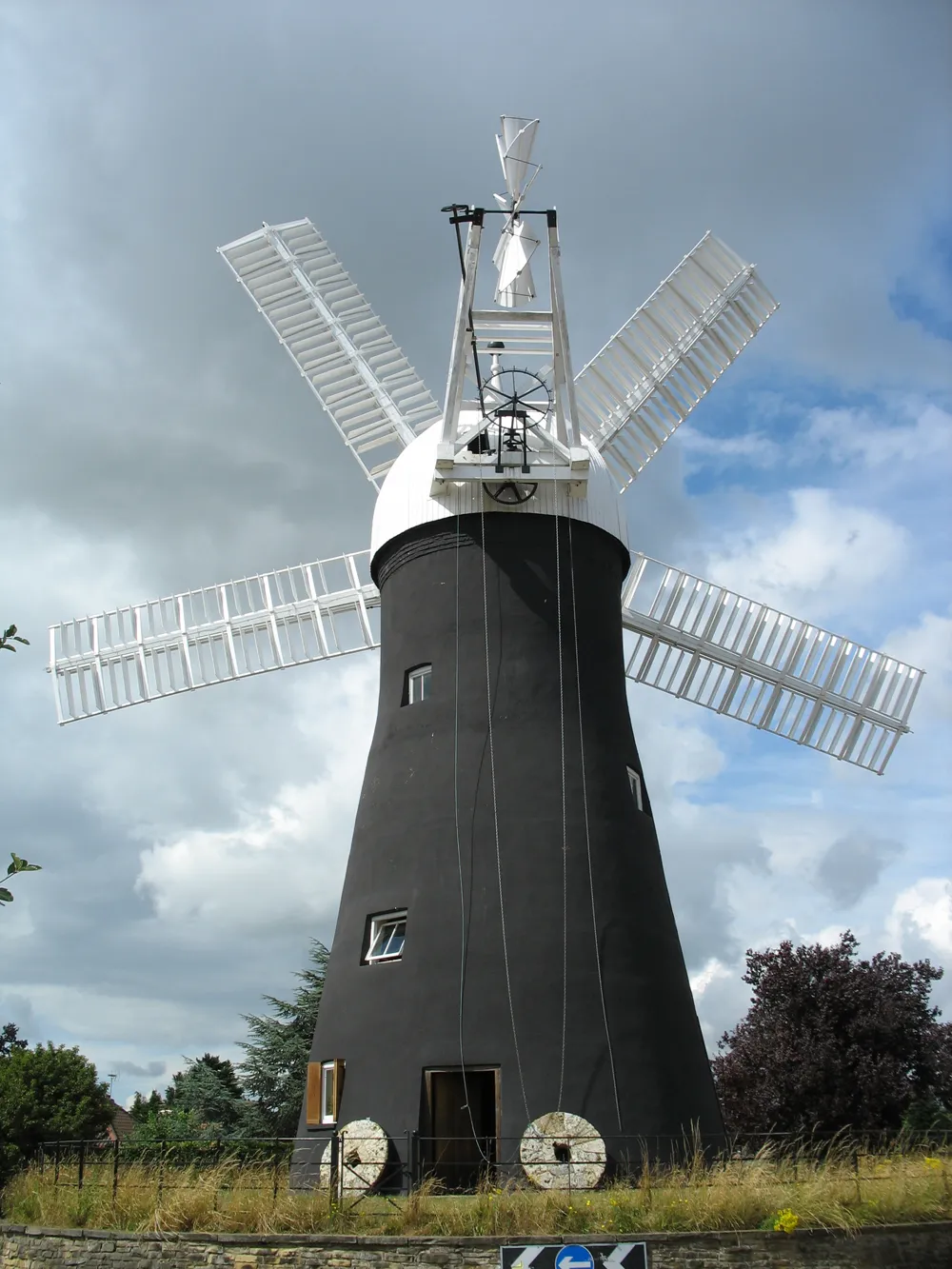 Molino de torre negra con cinco aspas blancas sobre un cielo nublado, Holgate Windmill en York