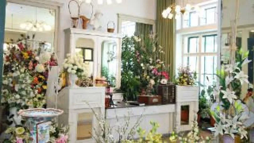 interior of a museum with floral arrangements and plants on display