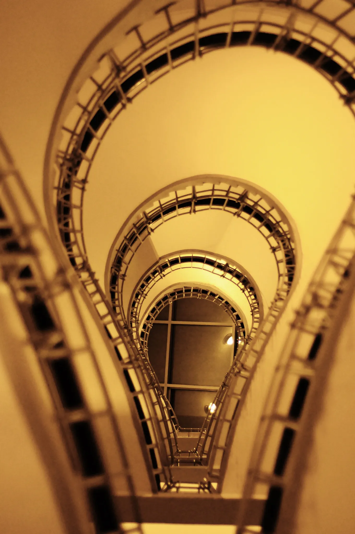 Kręcone schody z geometrycznymi balustradami i ciepłym oświetleniem wewnątrz budynku