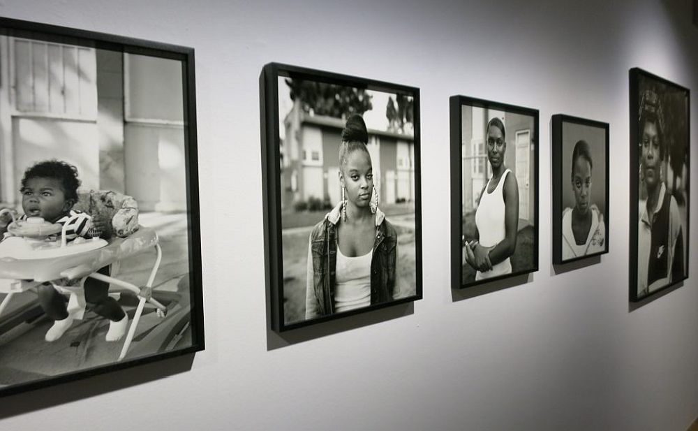 Black-and-white photographic portraits displayed in frames on a museum wall