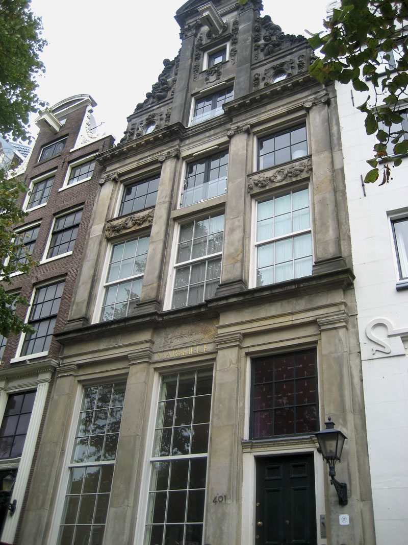 Stone facade of Huis Marseille Museum for Photography with ornate gable, large windows, address 401, and entrance door