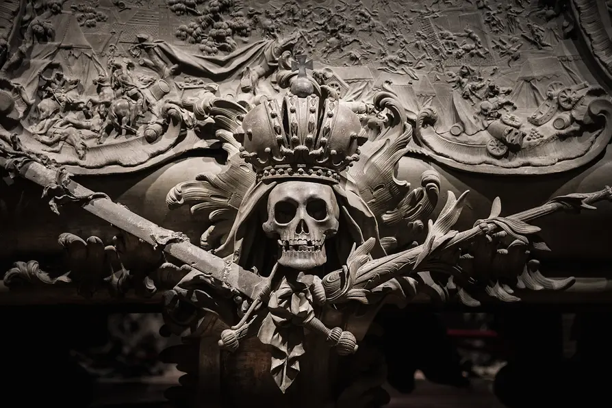 Close-up van een grafmonument met een gekroonde schedel en gekruiste zwaarden