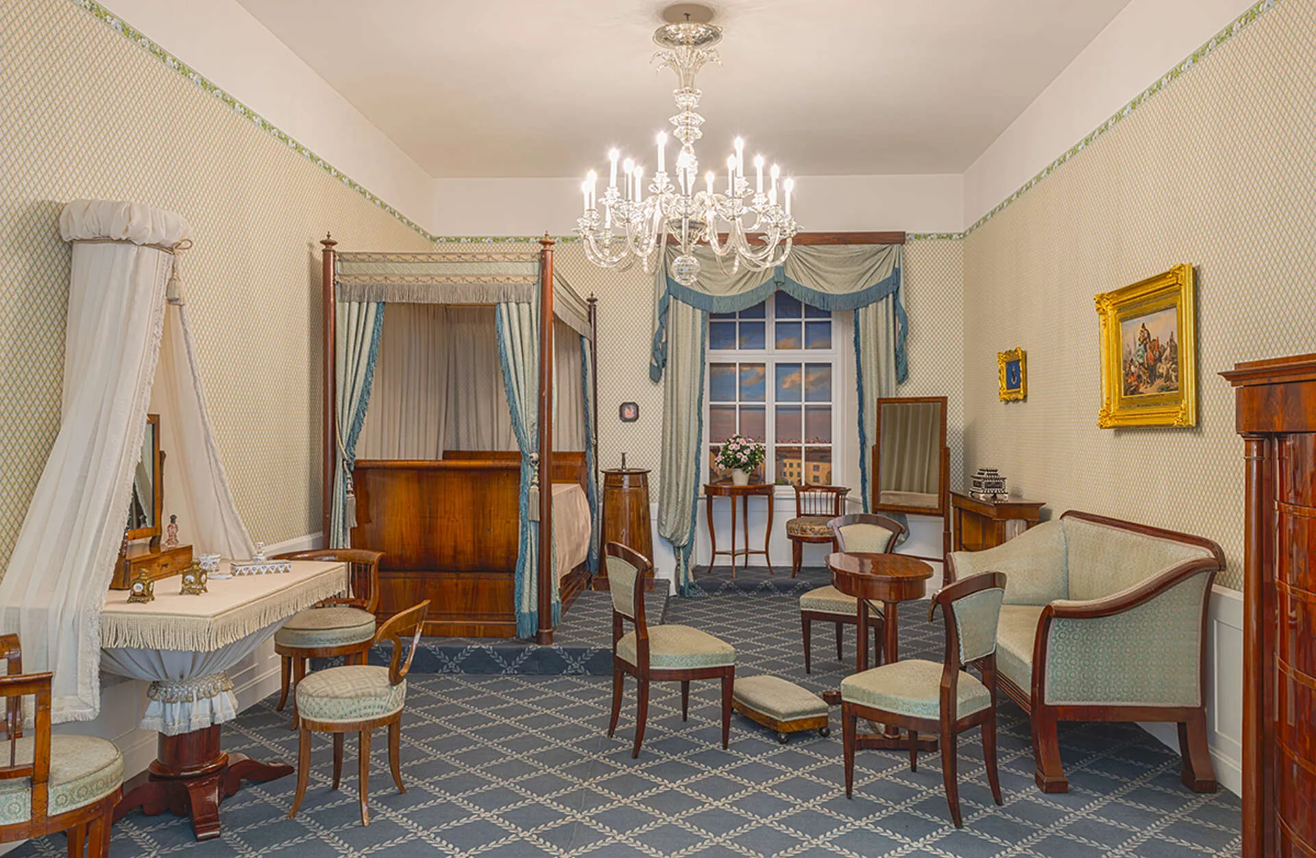 Un dormitorio histórico con cama con dosel, candelabro y muebles de época