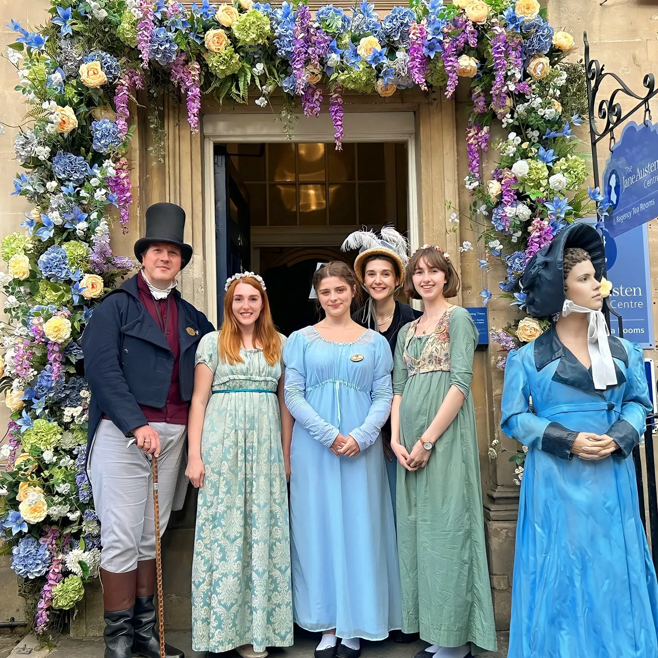 Gospodarze w strojach z epoki regencji przed wejściem do Jane Austen Centre przy ulicy Gay Street w Bath.