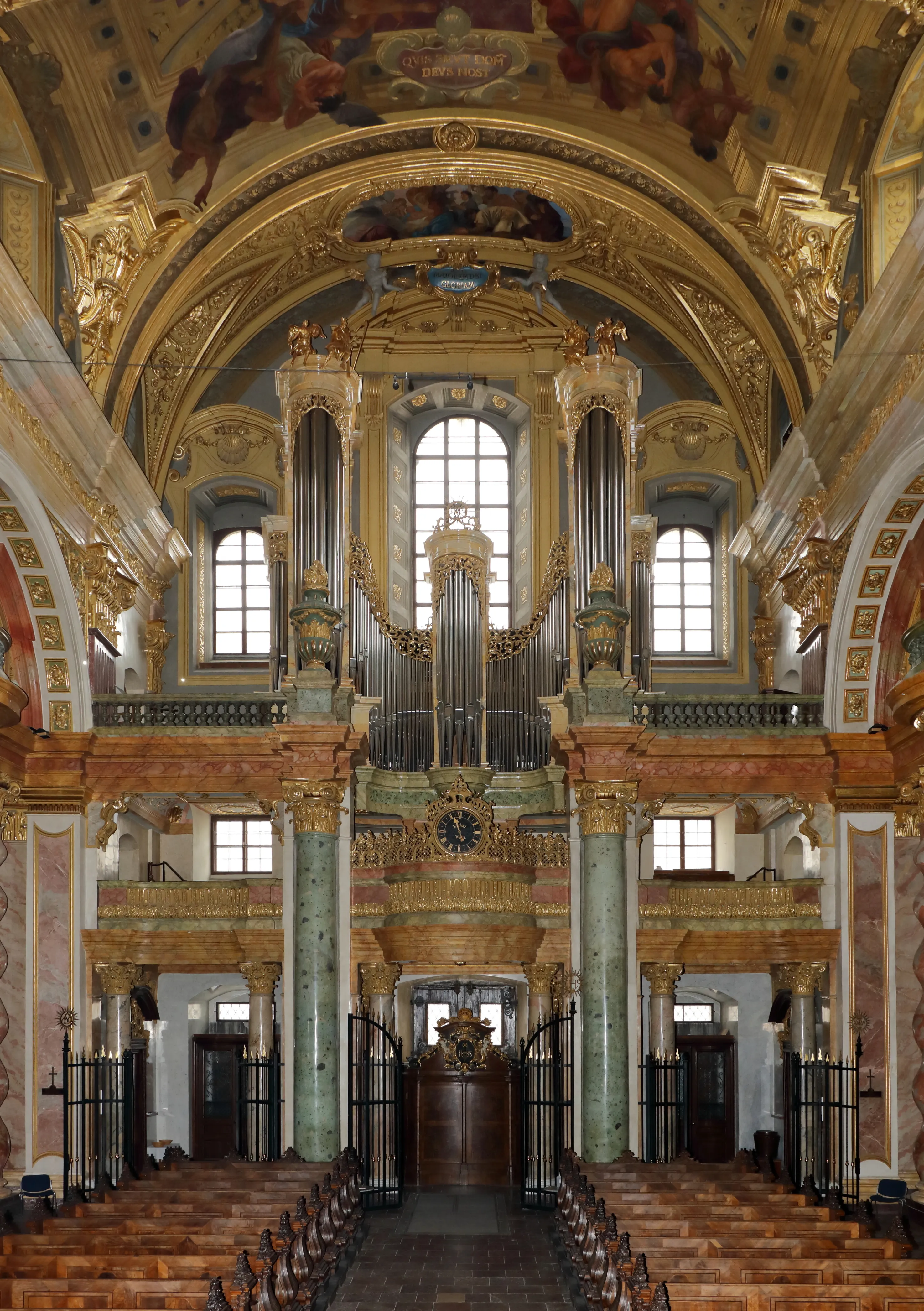Interior de la Iglesia de los Jesuitas con un gran órgano de tubos en una galería, ornamentado detalle dorado y frescos en el techo