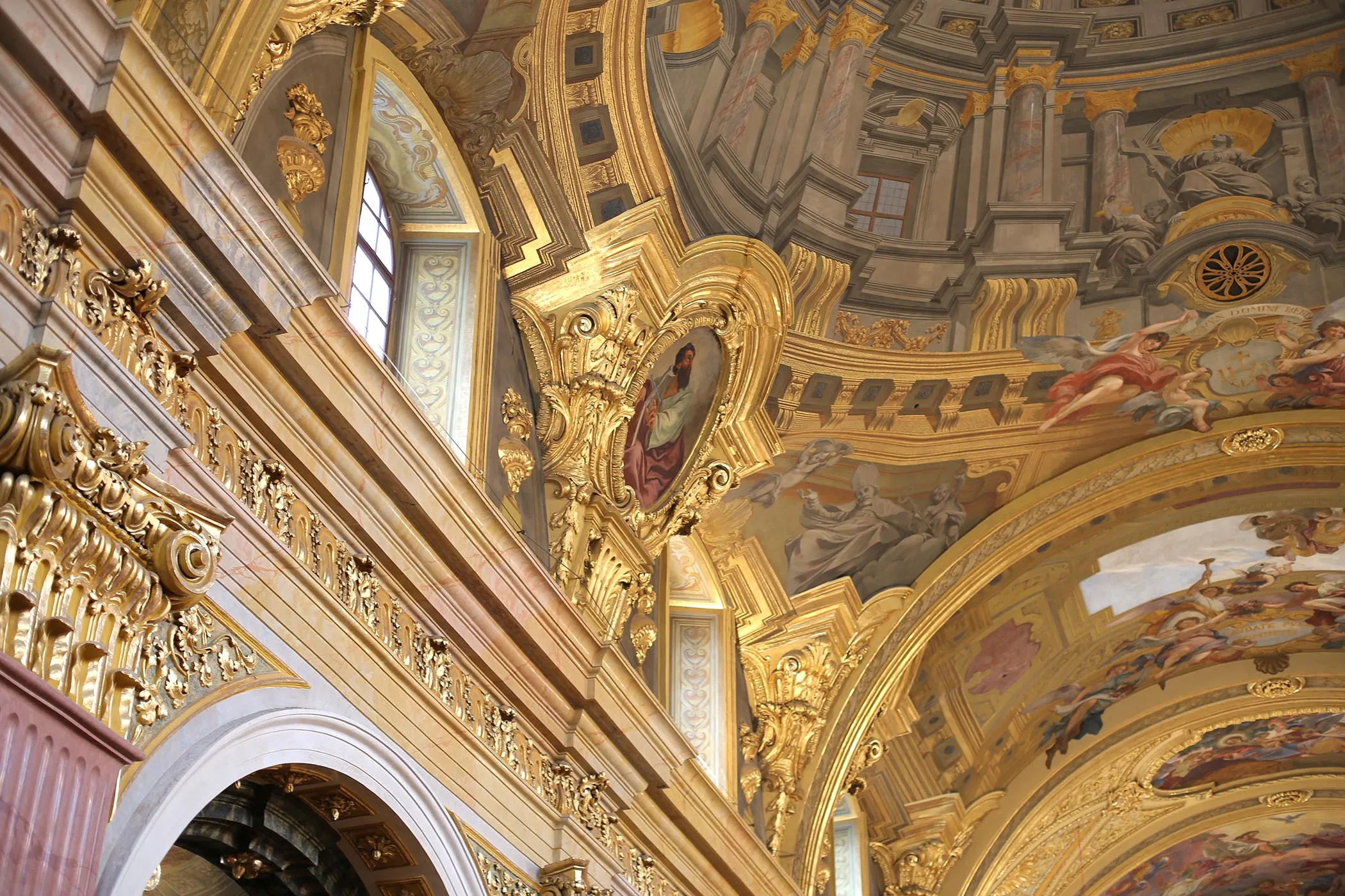 Interieur van de Jezuïetenkerk met gouden sierornamenten en geschilderde plafondfresco's