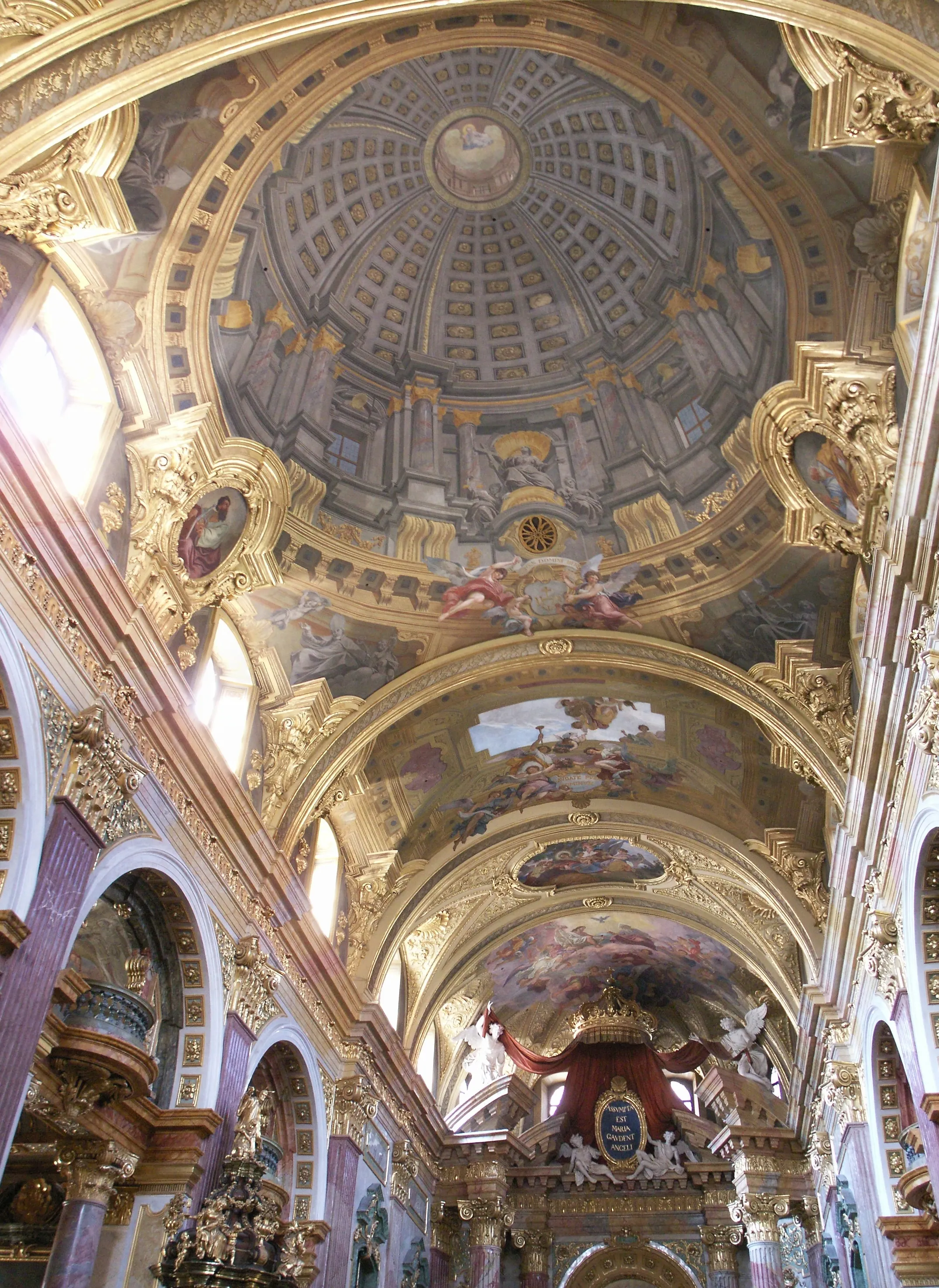 Interior de la Iglesia de los Jesuitas con un techo abovedado pintado con frescos, doradas decoraciones ornamentales y techos arqueados