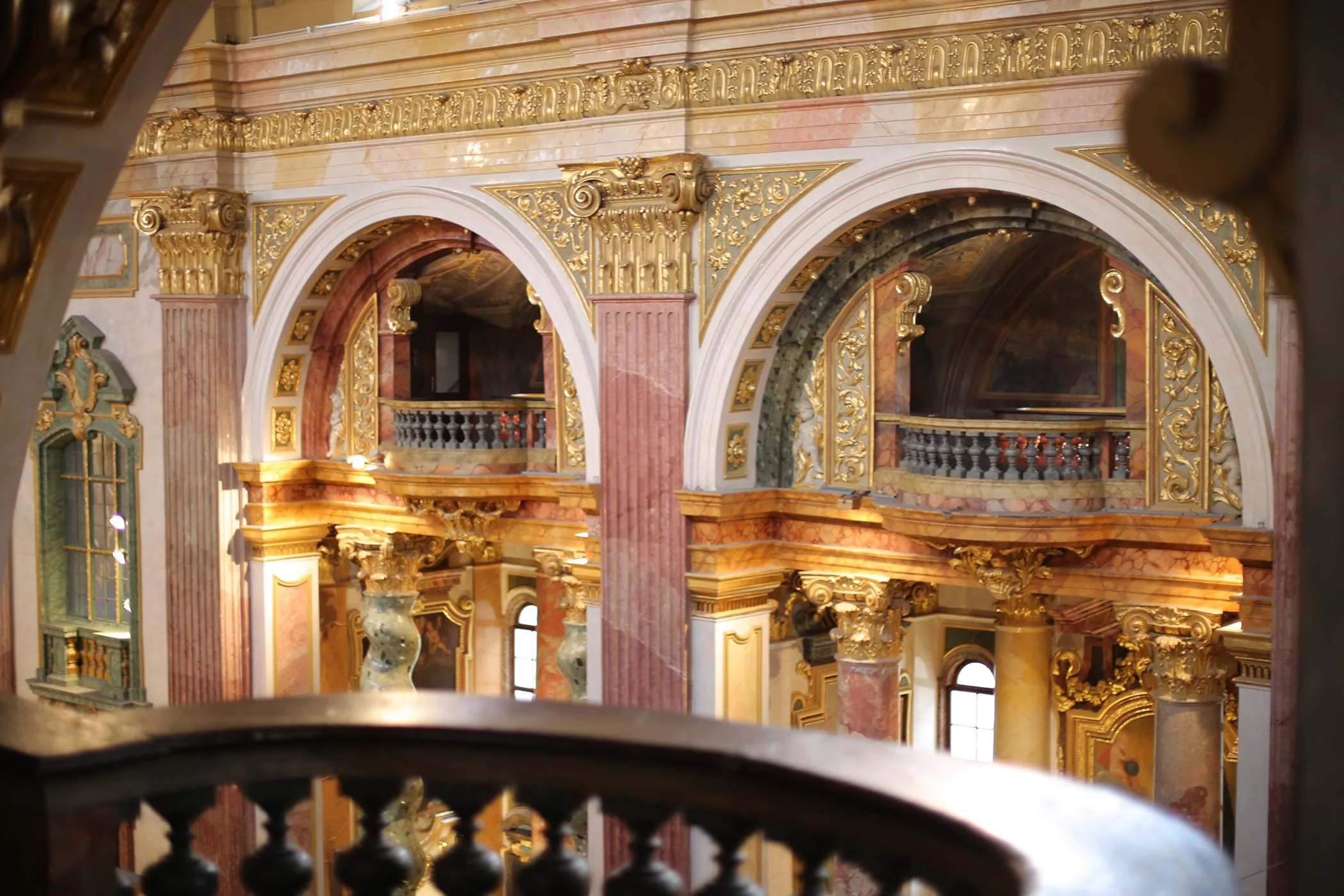 Vista interior de la Iglesia jesuita con arquitectura barroca dorada, techos abovedados y detalles ornamentados