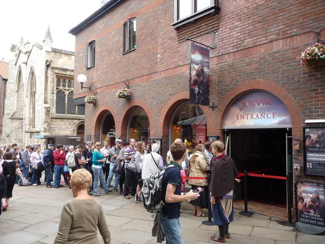 Ceglany budynek z łukowatym wejściem oznaczonym napisem JORVIK ENTRANCE, przed którym na wybrukowanej ulicy stoi długa kolejka zwiedzających.