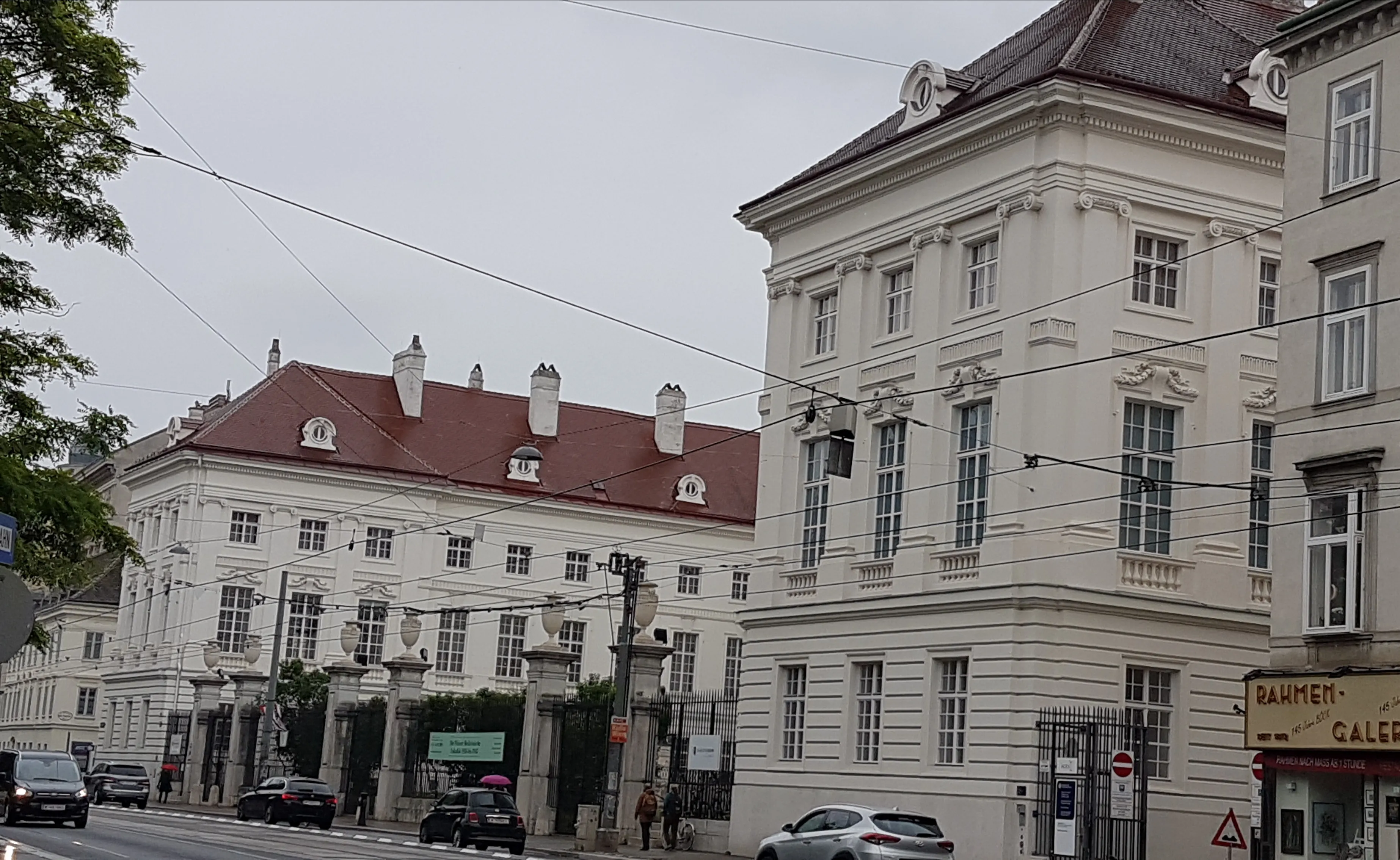 white classical building with red roof and multiple windows