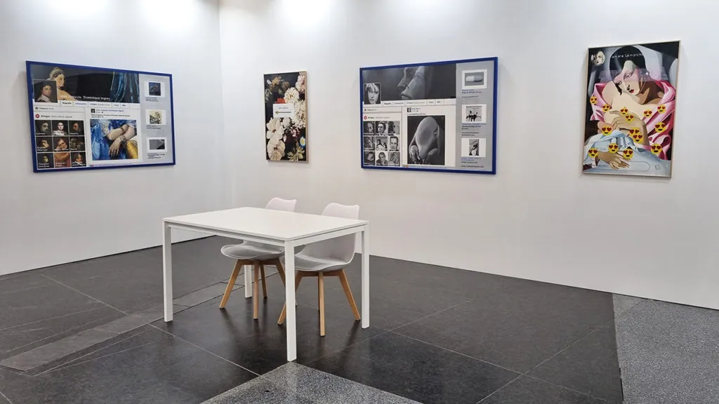 Interior of Juan Manuel Lumbreras Gallery showing framed photographic artworks mounted on white walls with a white table and chairs centered on a dark gray tile floor