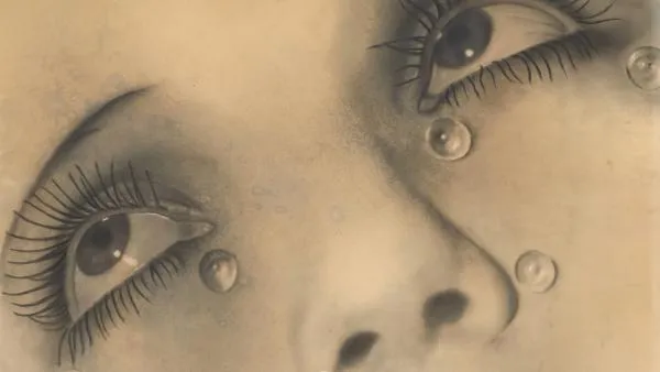 close-up of a woman's face with tears and long eyelashes