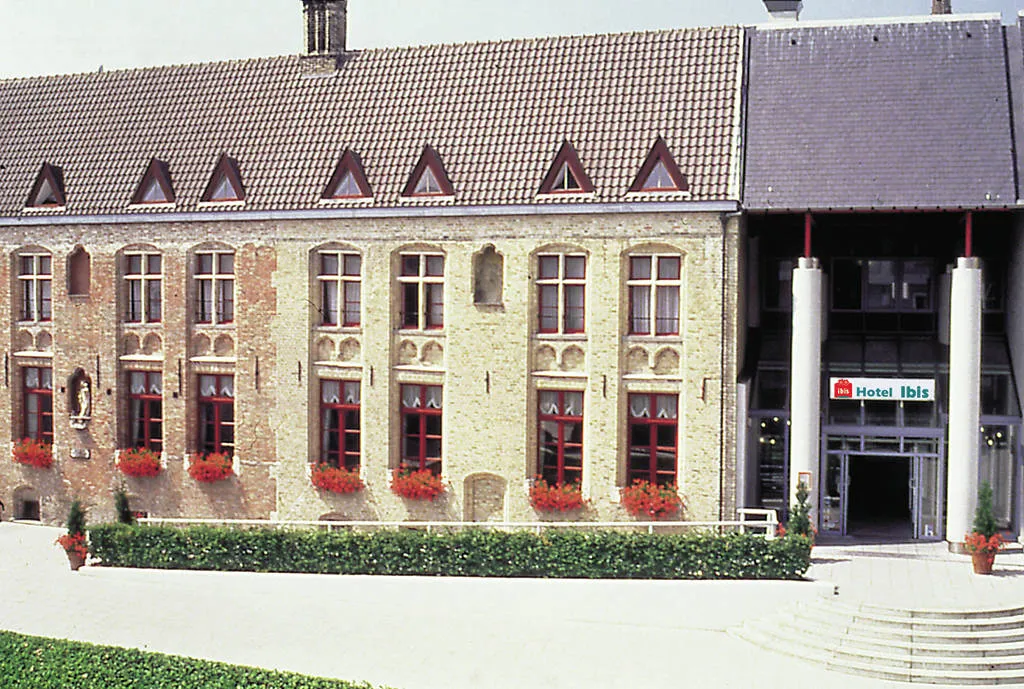 Vista exterior del edificio Kantcentrum que presenta una fachada histórica de ladrillo con jardineras rojas y una entrada moderna con columnas.